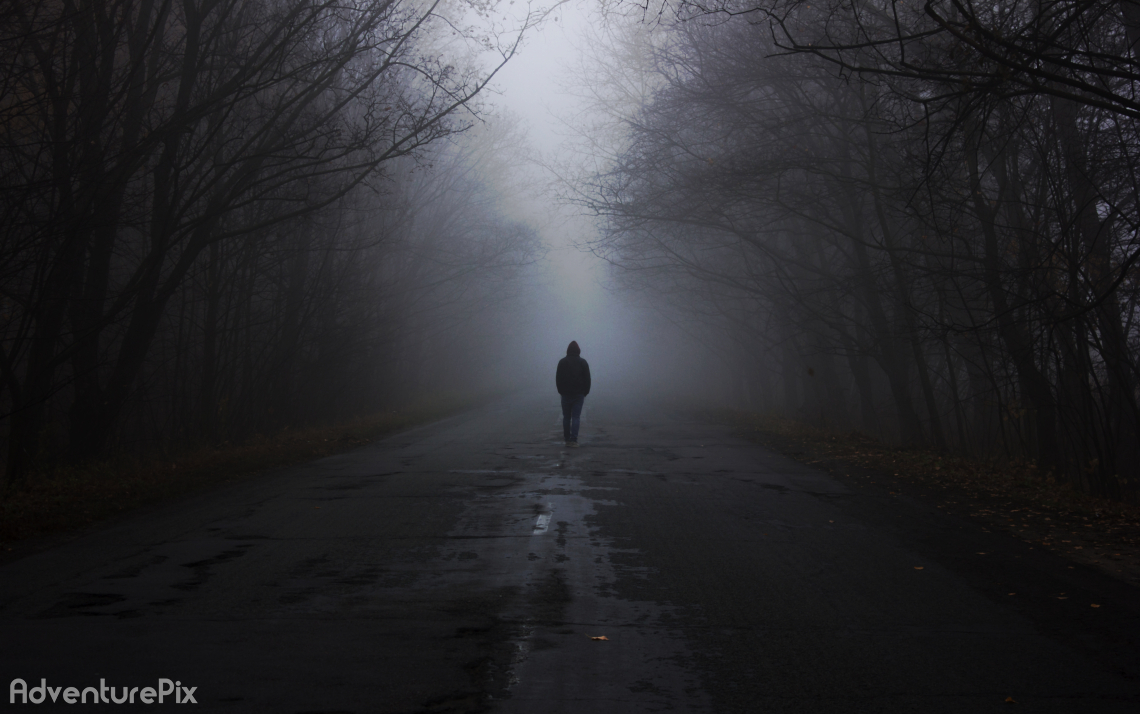 Man in a fog walks down the road
